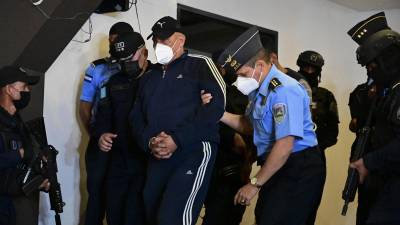 Juan Carlos “El Tigre” Bonilla, ex jefe de la Policía Nacional de Honduras, es escoltado luego de ser arrestado por ser buscado en los EEUU por presunto tráfico de drogas, en Tegucigalpa, el 9 de marzo de 2022.