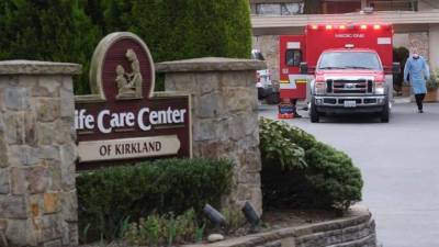 El personal de emergencia vestido con ropa protectora se prepara para transportar a una persona desde el Centro de Vida de Kirkland, donde varios residentes contrajeron el nuevo coronavirus, en Kirkland, Washington, EEUU. EFE / EPA / Stephen Brashear