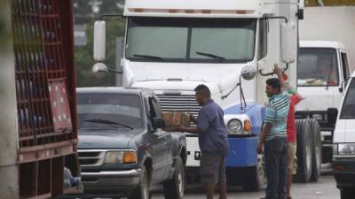 Una gran cantidad de personas ha salido a pedir dinero a la carretera que está entre La Lima, Cortés, y El Progreso, Yoro, en uno de los tramos en que se encuentran las carpas improvisadas a las que se mudaron temporalmente las personas que afectadas por las lluvias. Quienes piden dinero afirman ser damnificados. FOTOS: AMÍLCAR IZAGUIRRE