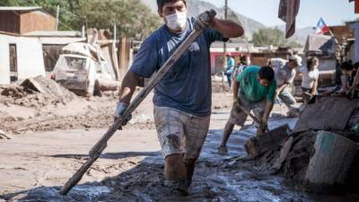 Un vecino colabora en las tareas de limpiar las calles de lodo en la localidad de Paipote.