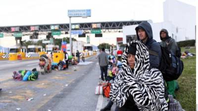 Decenas de migrantes aguardan en la frontera de Tijuana con la esperanza de cruzar hacia EEUU.