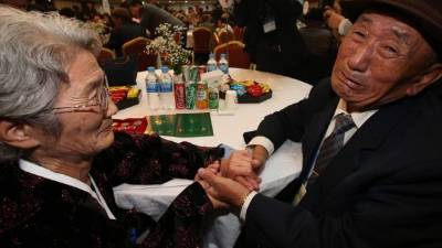 La norcoreana Kim Joen-Soon estrecha la mano de su hermano surcoreanoKim Bok-Rak. Fotos: AFP y EFE