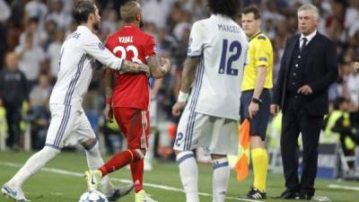 El centrocampista chileno del Bayern, Arturo Vidal (2i), empujado por el defensa del Real Madrid, Sergio Ramos, tras ser expulsado durante el encuentro correspondiente a la vuelta de los cuartos de final. FOTO EFE