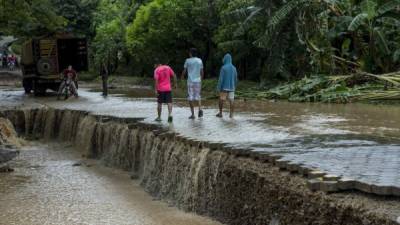 Tres jóvenes caminan por un puente dañado por las lluvias hoy, viernes 6 de octubre de 2017, después el paso de la tormenta Nate por la ciudad de Rivas (Nicaragua). EFE