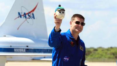 Especialista de misión de Artemis II, Jeremy Hansen, de la Agencia Espacial Canadiense (CSA), sosteniendo Rise, la mascota lunar e indicador de gravedad cero para el vuelo de prueba alrededor de la luna.