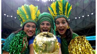 Tres bellas brasileñas posan con la “Copa del Mundo” en el estadio Lusail de Qatar.