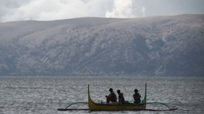 El 14 de enero de 2020, se ve vegetación quemada en el lago cerca del volcán Taal visto desde la ciudad de Balete, provincia de Batangas, al sur de Manila. El volcán Taal en Filipinas podría arrojar lava y cenizas durante semanas, advirtieron las autoridades el 14 de enero, dejando a miles en el limbo después de huyendo de sus hogares por temor a una erupción masiva. / AFP / Ted ALJIBE