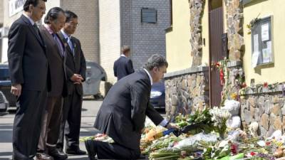 El presidente ucraniano, Petro Poroshenko, coloca flores en la embajada de Malasia en Kiev en memoria a las víctimas del vuelo de Malaysia Airlines MH17 derribado el 17 de julio.