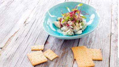 Servir el ceviche de pescado con galletas.