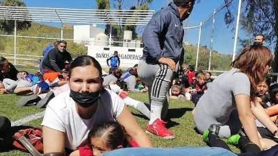 Varios niños y sus padres se protegen durante una balacera en la que murieron cuatro policías en México.