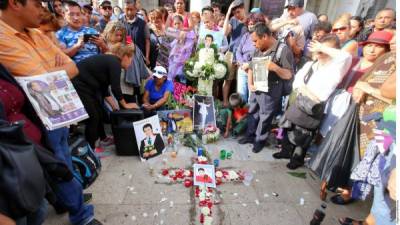 A las afueras del Palacio de Bellas Artes, admiradores de Juan Gabriel entonan sus canciones y llevan flores, letreros y fotos para recordar al fallecido cantante mexicano.