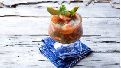 Sirva el coctel en una copa decorada con aguacate.