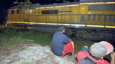 Dos migrantes esperan el tren en Palenque, estado de Chiapas, México. (AFP)