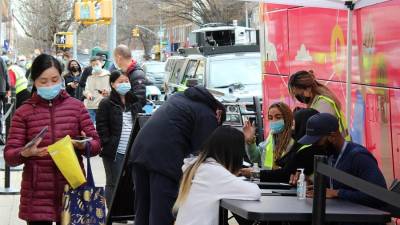 Funcionarios del Departamento de Salud de Nueva York comprueban los datos de las personas que esperan para vacunarse contra la covid-19.