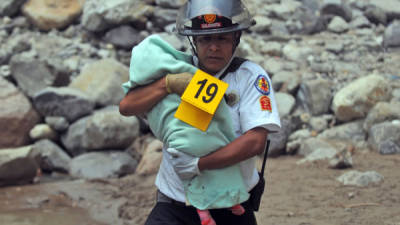 Un bombero rescata el cuerpo de un bebé que murió en un accidente en Guatemala.