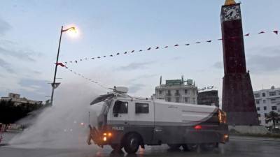 Camiones de la policía tunecina rocían desinfectante, como medida contra la pandemia de coronavirus. Foto: AFP