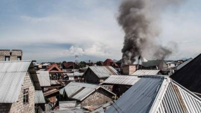 Smoke raises after a small aircraft crashed in a densely populated area in Goma on the East of the Democratic Republic of Congo on November 24, 2019. - A Dornier-228 aircraft had been headed for Beni, 350 kilometres (220 miles) north of Goma when it went down in a residential area near the airport in the east of the country. (Photo by PAMELA TULIZO / AFP)