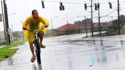 Una persona transita bajo la lluvia antes de la llegada del huracán Matthew a la costa de ciudad de Cocoa Beach, en Florida hoy, 6 de octubre de 2016. EFE