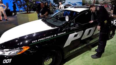 Un oficial de la Policía de Nueva York observa el vehículo Ford Police Interceptor 2018. EFE/Archivo