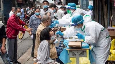Trabajadores de la salud realizan pruebas de coronavirus en Wuhan. Foto: AFP