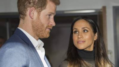 Britain's Prince Harry and his fiancee, US actress Meghan Markle gesture during their visit to Nottingham Academy in Nottingham, central England, on December 1, 2017. Prince Harry and his American actress fiancee Meghan Markle were welcomed by hundreds of people on their first royal visit as a couple since announcing their engagement this week. / AFP PHOTO / POOL / Andy Stenning