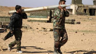 Dos soldados sirios cargan un proyectil en el frente de la ciudad de Raqqa, donde luchan contra opositores al Gobierno.