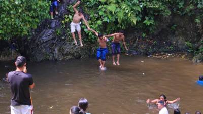 Mientras las personas los observan, los tres amigos se lanzan juntos desde una de las alturas.