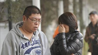 Dos personas que tienen familiares en el accidente de un avión de Malaysia Airlines esperan noticias fuera del hotel, donde los familiares de los pasajeros se reunieron hoy en Pekín, China. EFE