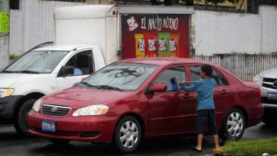 Un niño limpia parabarisas en una calle de San Salvador