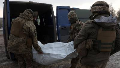 Militares ucranianos recogen el cuerpo de uno de sus compañeros tras combates contra las tropas rusas en la región de Donetsk.