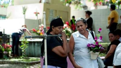 Personas visitan tumbas en un cementerio de Tegucigalpa este, 2 de noviembre de 2015, cuando se conmemora el Día de los Difuntos. Foto EFE.