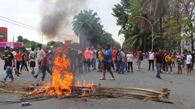 Migrantes centroamericanos y africanos queman palmeras durante unos enfrentamientos hoy, en Tapachula (México). EFE/ Juan Manuel Blanco.