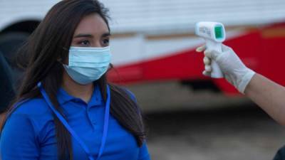 A woman has her temperature checked before entering the National Soccer Stadium during the final between Managua FC and Real Esteli in Managua, Nicaragua on May 9, 2020. (Photo by INTI OCON / AFP)