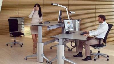 Los escritorios ajustables que permiten trabajar sentado o de pie pueden ser beneficiosos para la salud.