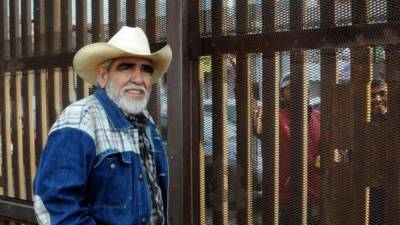 Claudio Cesma, oriundo de la ciudad californiana de Brawley, se reúne con sus familiares Rubén Uruchurtu y José Armando Rivero, que están al otro lado del muro fronterizo con México./EFE.