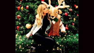 La modelo Carmen Electra se ve hermosa junto a su venado y árbol de Navidad.