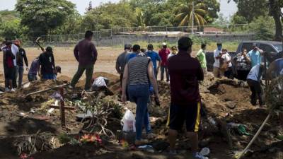 Personas asisten a entierro en un cementerio público este sábado en Managua. Foto: EFE