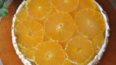 La tarta se decora con rodajas de naranjas.
