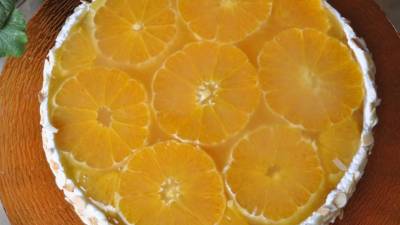 La tarta se decora con rodajas de naranjas.