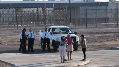 ELY01. ELOY (AZ, EE.UU.), 07/10/2016.- Fotógrafos retratan a una manifestante mientras la organización Observatorio de la Escuela de las Américas realiza una vigilia hoy, 7 de octubre de 2016, a las afueras de Centro de Detenciones de Eloy de la Oficina de Inmigración y Aduanas (ICE) el cual se encuentra aproximadamente a una hora al norte de la ciudad de Tucson. Más de 430 organizaciones defensoras de los derechos humanos y de los migrantes se reúnen en la frontera de Arizona con México a partir de hoy para pedir un alto a la militarización de la frontera y denunciar las políticas exteriores de los Estados Unidos, las cuales consideran son la raíz de la migración indocumentada proveniente de diferentes países latinoamericanos. EFE/GARY M WILLIAMS