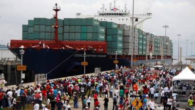 TOPSHOT - Chinese-chartered merchant ship Cosco Shipping Panama crosses the new Agua Clara Locks during the inauguration of the expansion of the Panama Canal in Colon, 80 km from Panama City on June 26, 2016.A giant Chinese-chartered freighter nudged its way into the expanded Panama Canal on Sunday to mark the completion of nearly a decade of work forecast to boost global trade. / AFP PHOTO / EDUARDO GRIMALDO