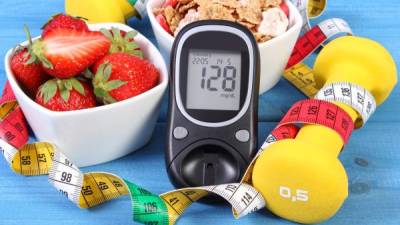 Glucose meter with result of measurement sugar level, healthy food, dumbbells for fitness and tape measure, concept of diabetes, slimming, healthy lifestyle