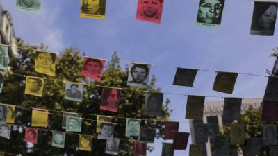 Vista de fotografías con retratos de desaparecidos durante la dictadura militar argentina que cuelgan sobre una calle de Buenos Aires. EFE/Archivo