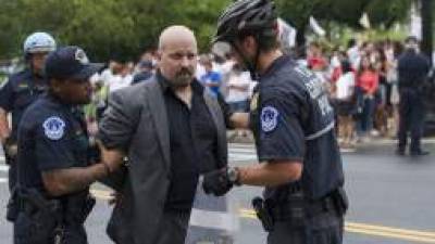 A demonstrator (C) is arrested by US Capitol Police during an immigration protest near the US Capitol in Washington, DC, August 1, 2013. Some 40 pro-immigration activists have been arrested outside the US Capitol after blocking traffic while pushing for passage of legislation overhauling the system. AFP PHOTO/JIM WATSON