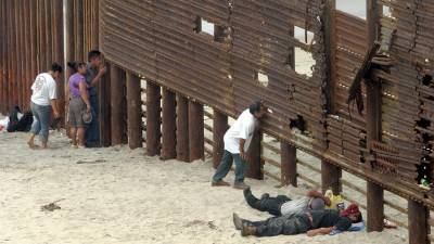 Fotografía de archivo de migrantes mexicanos que observan los movimientos de la patrulla fronteriza en la frontera con Arizona.