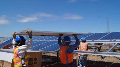 Trabajadores instalan los paneles fotovoltaicos en una planta de la zona sur.