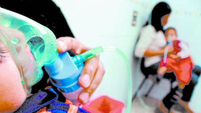 <b>Dos niños son atendidos por complicaciones respiratorias en un hospital de Honduras. Fotos: La Prensa</b>