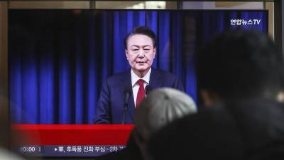 Una pantalla de televisión muestra una transmisión en vivo del presidente de Corea del Sur, Yoon Suk Yeol, dirigiéndose a la nación.
