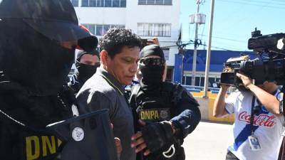 Miembros de la Dirección Antidrogas de la Policía trasladan a los tribunales de justicia al exfutbolista hondureño Oscar “Pescado” Bonilla, acusado de narcotráfico en Tegucigalpa.