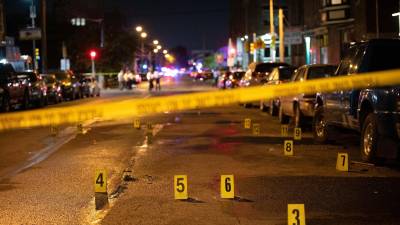 Oficiales de policía trabajan en la escena de un tiroteo masivo en Kingsessing, en el suroeste de Filadelfia, Pensilvania.
